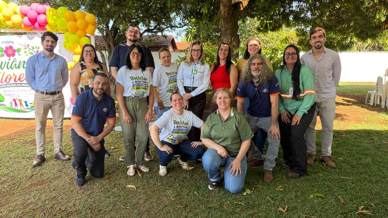 Equipe da ATG e parceiros reunidos junto ao painel do Joviânia Floresce